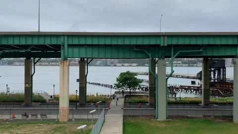 NYC - Runners &amp; Cyclists exercise on Hudson River Greenway past Pier I Gantry Stock Footage 117620253