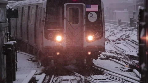NYC subway train pulls into station on a snowy day Stock Footage 63320996