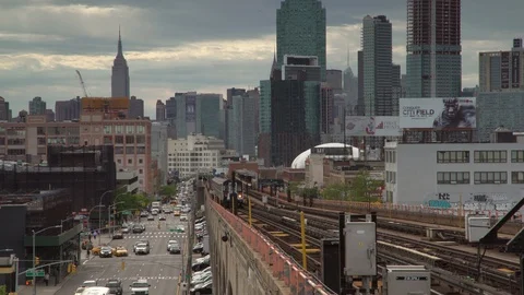 NYC Subway train pulls into station with iconic skyline in background Stock Footage 91359333