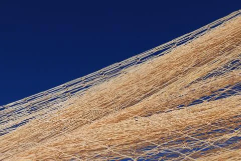 Nylon fishnet texture on the clear sky. Nautical marine background. Macro clo Stock Photos