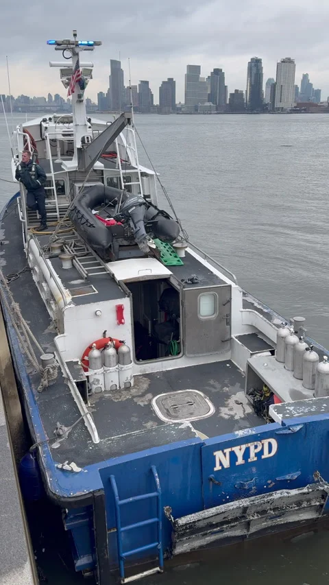 An NYPD Harbor Unit SCUBA support launch is docked along East River Park Stock Footage 343311610