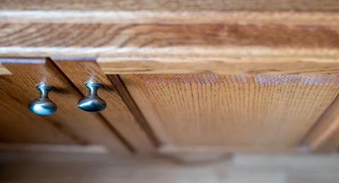 Oak cabinet doors with metal knobs and narrow depth of field Stock Photos