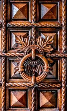Oak panel door background with large round wood door knocker. Stock Photos