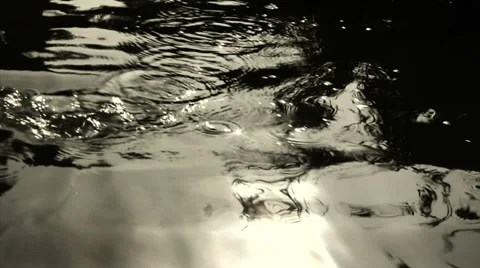 An oar is pulled into river water and disturbing the reflection. Stock Footage 27520650
