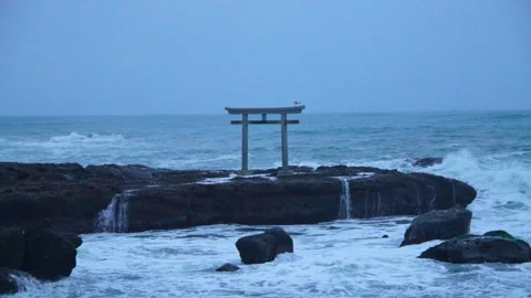 Oarai, Japan – 2025/10/15: Ocean waves striking coastal rocks with torii gate Stock Footage 321106901