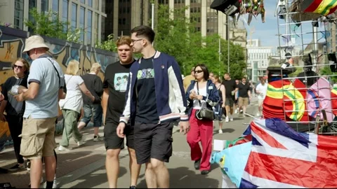 Oasis fans stream through city centre streets and stalls ahead of concert Stock Footage 312470146