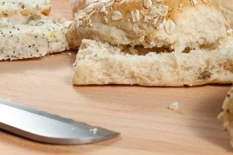 Oat flake bread rolls laying on a wodden breadboard Stock Photos