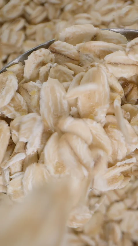 Oat flakes falling from above onto a spoon, a healthy breakfast, top view, backg Stock Footage 265733526