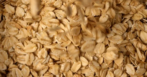 Oat flakes falling and rotating in slow motion. Extreme close up top view, shot Stock Footage 107393772