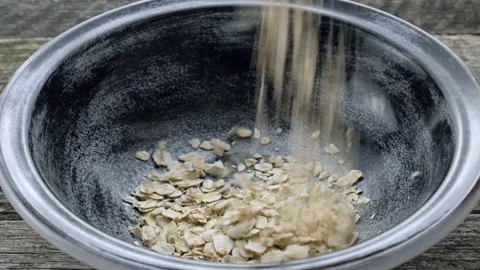 Oat flakes falling into bowl. Closeup Stock Footage 160736348