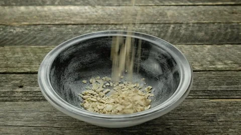 Oat flakes falling into bowl Video stock 143525828