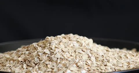 Oat flakes grains rotating on black background Stock Footage 146997891