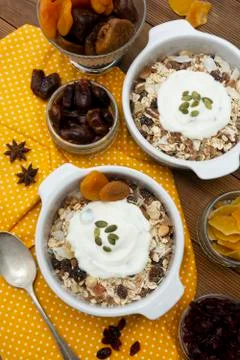 Oat flakes with nuts, dried fruit mix in bowl over rustic wooden table, isola Stock-Fotos