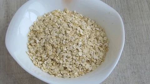 Oat flakes in  plate fall peach slices slow motion footage Video stock 78934863
