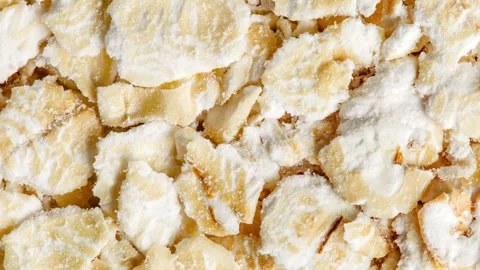 Oat flakes raw, bunch in bulk, rotating, turning, close-up Video stock 240642001