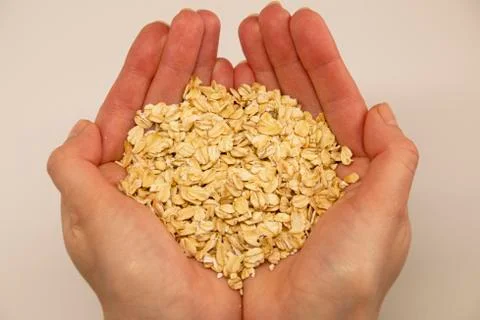 Oat grain in the palms on a white background, top view Stock Photos
