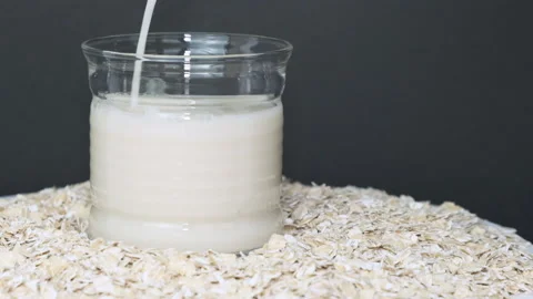 Oat milk in transparent cup, poured into glass Stock Footage 133359837