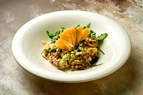 Oatmeal with avocado mousse and mango in a bowl. Selective focus, close-up Stock Photos