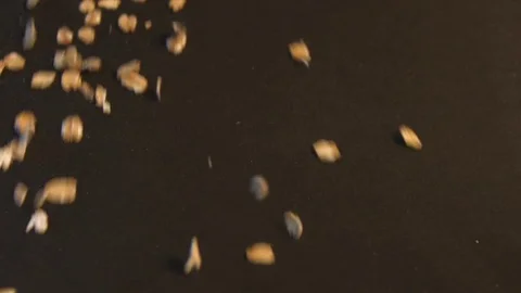 Oatmeal on a black background. Slow motion. Vertical pan. Close-up. Видео 70046026