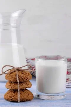 Oatmeal cookies piled in the stack in the foreground and milk in a glass on a Stock Photos