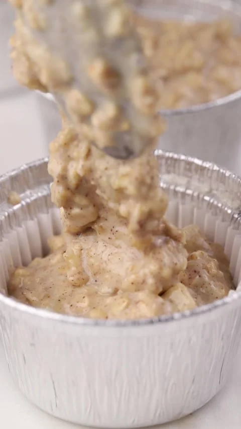 Oatmeal cupcake batter spooned into foil liners Stock Footage 290804346