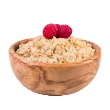 Oatmeal with raspberry berries in a wooden bowl isolated on a white background. Stock Photos