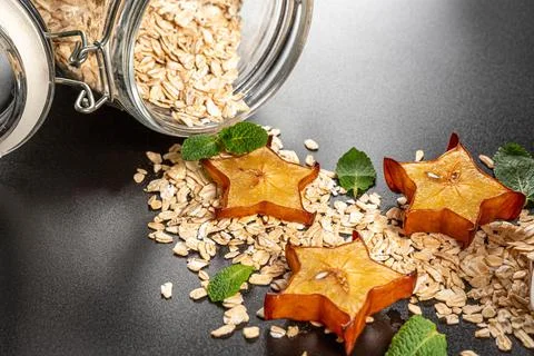 Oatmeal with slices of carom and mint leaves poured from a jar, close-up Stock Photos