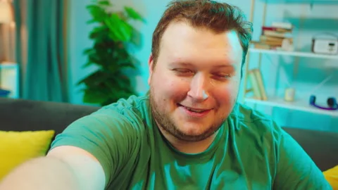 Obese man crying and smiling at the same time he telling a story while recording Video stock 146476181