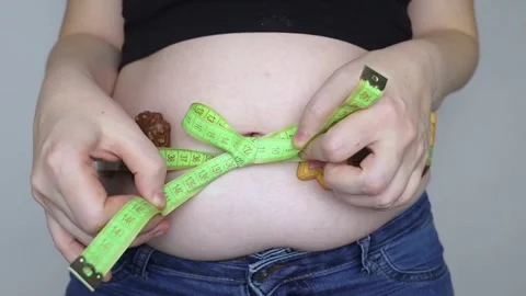 Obesity and overweight from overeating. Big belly tied with measuring tape as gi Stock Footage 295027341