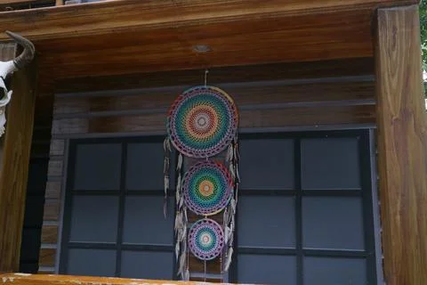 An object called a dream catcher hung on a wooden wall Stock Photos
