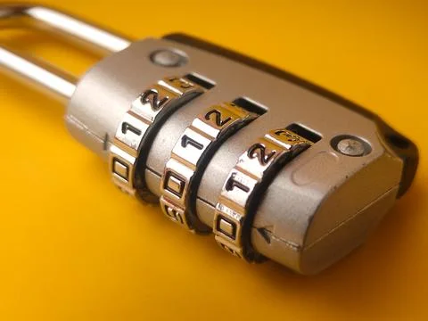 The object shown in the image is asmall combination padlock on a yellow bac.. Stock Photos