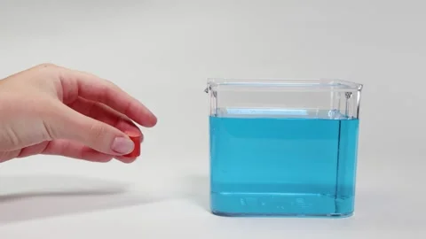 Object Sinking Experiment in Blue Liquid Video stock 309354622