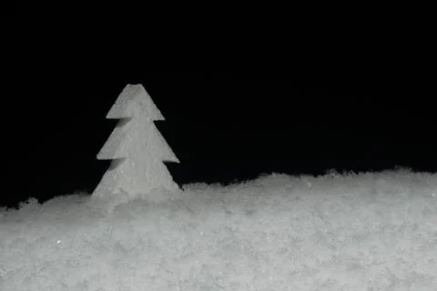 Object white foam Christmas tree in snow. on black background Stock Photos