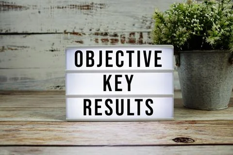 Objective Key Results text on light box with alarm clock on wooden background Stockfoto's