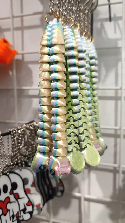 Objects keychains form caterpillar, models toys printed on 3D printer. Vertical Stockbeeldmateriaal 304079108