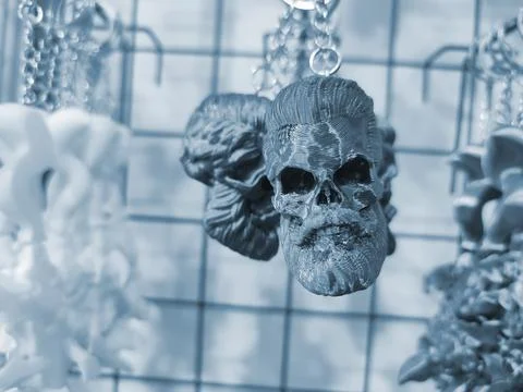 Objects keychains form skull man models of toys printed on 3D printer Blue Stock Photos