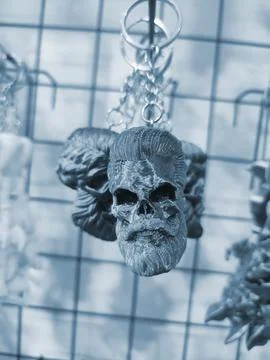 Objects keychains form skull man models of toys printed on 3D printer Blue Stock Photos
