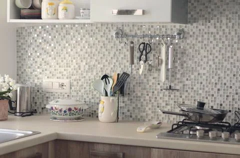 Objects on kitchen workspace with mosaic tile wall. Traditional apartment Stock Photos