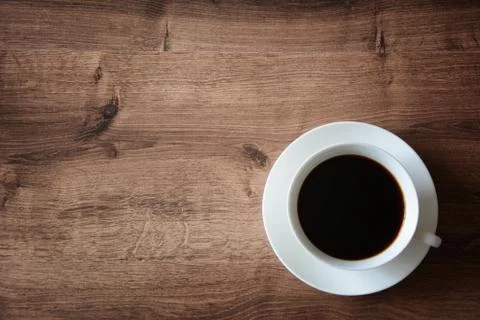 Objects on a wooden table a cup of coffee and a book Stock Photos
