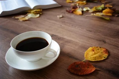 Objects on a wooden table a cup of coffee and a book Stock Photos
