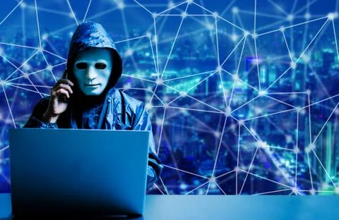 Obscured dark face using computer for cyber attack and calling on cellphone 스톡 사진