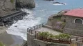 Observation deck and tiny hut aside facing seashore with waves rolling on shore HD Footage
