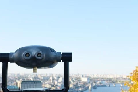 Observation deck with binoculars overlooking a vibrant cityscape, showcasing Stock Photos