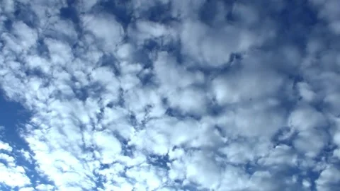 Observe stunning cloud formations drifting across a vibrant blue sky during a Stock Footage 292752793
