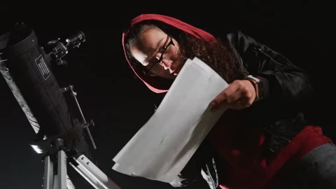 Observer examines celestial charts. Nighttime sky watcher studies printed Stock Footage 328054909