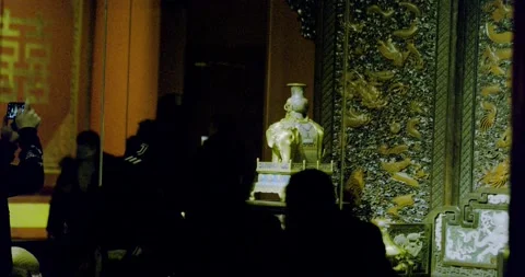 Observing golden Elephant on table next to jade dragon chair Stock Footage 143411366