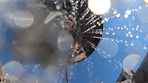 Observing a person taking a refreshing shower outdoors, with water spraying and Stock Footage 342760677