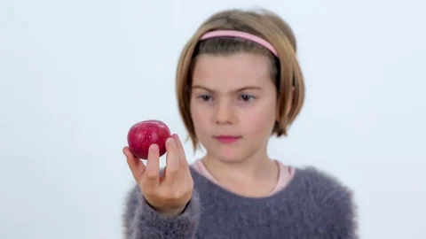Observing a small red apple in her hand Stock Footage 83724710