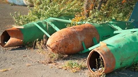 Obsolete, abandoned, and rusty combat missiles and shells stand amidst the .. Stock-Footage 345596599