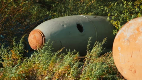 Obsolete, abandoned, and rusty combat missiles and shells stand amidst the .. Stock-Footage 345626579